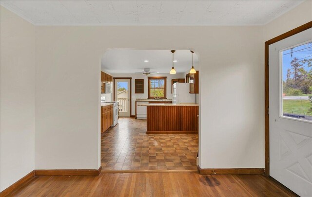 626 Main Rd, Eddington, ME 04428 - kitchen featuring white appliances, baseboards, hardwood / wood-style floors, light countertops, and a peninsula