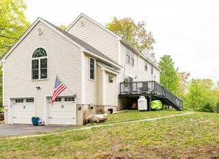 77 Cemetery Rd, Berwick, ME 03901 - view of side of home with an attached garage, stairway, asphalt driveway, a deck, and a yard