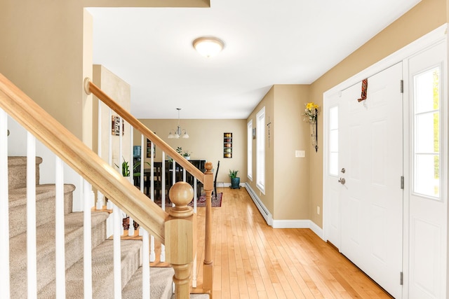 77 Cemetery Rd, Berwick, ME 03901 - foyer entrance featuring a baseboard heating unit, stairway, a chandelier, light wood finished floors, and healthy amount of natural light