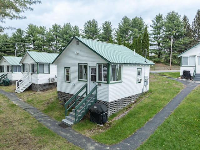 750 Roosevelt Trl Unit 7, Naples, ME 04055 - view of front of house with a sunroom, a front lawn, metal roof, and stairway