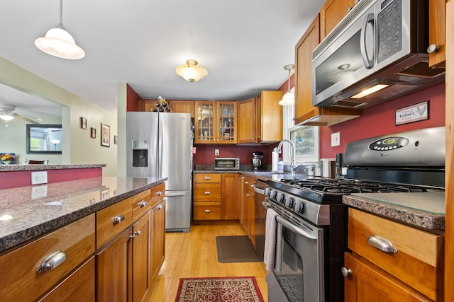 455 Duck Pond Rd, Westbrook, ME 04092 - kitchen with appliances with stainless steel finishes, a sink, brown cabinets, light wood-style floors, and glass insert cabinets