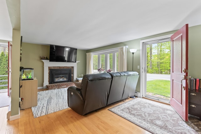 455 Duck Pond Rd, Westbrook, ME 04092 - living area featuring light wood-style floors, a brick fireplace, baseboard heating, and baseboards