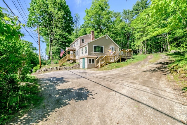 148 Naples Rd, Harrison, ME 04040 - rustic home with stairs, asphalt driveway, a chimney, and a deck
