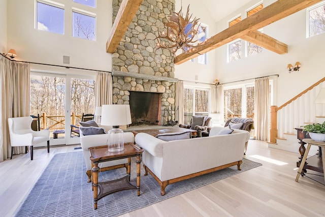 6065 Sandy River Cir, Carrabassett Valley, ME 04947 - living area with high vaulted ceiling, wood finished floors, healthy amount of natural light, a fireplace, and stairway