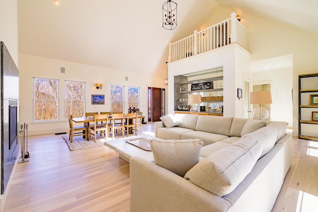 6065 Sandy River Cir, Carrabassett Valley, ME 04947 - living room featuring high vaulted ceiling, light wood-type flooring, healthy amount of natural light, and baseboards