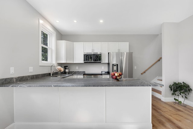 14 Depot St, Buxton, ME 04093 - kitchen with stainless steel appliances, a sink, white cabinetry, a peninsula, and light wood-style flooring