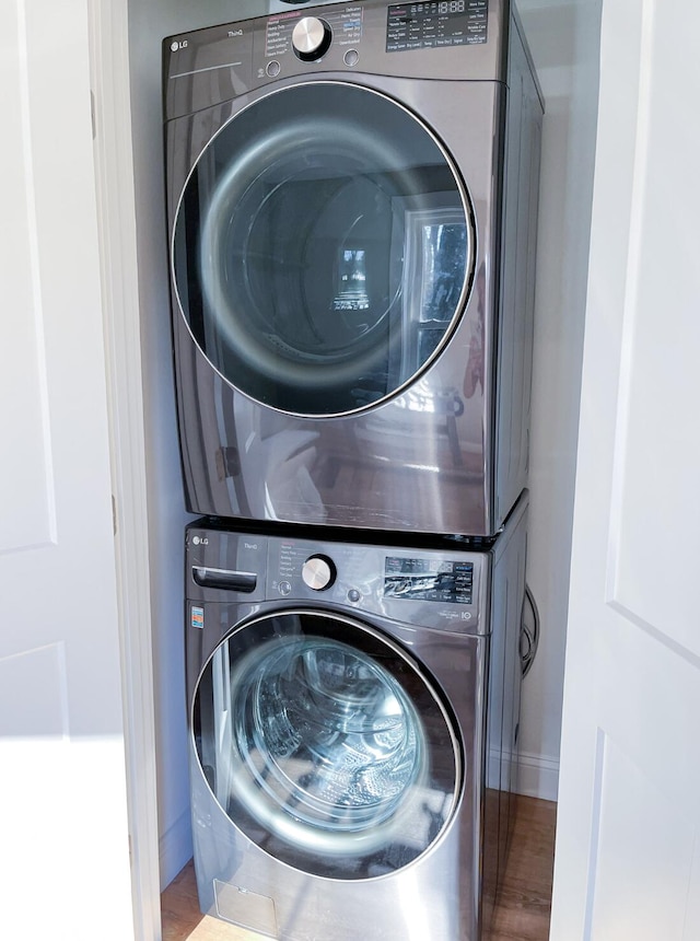 14 Depot St, Buxton, ME 04093 - laundry room featuring stacked washer and clothes dryer, wood finished floors, and baseboards