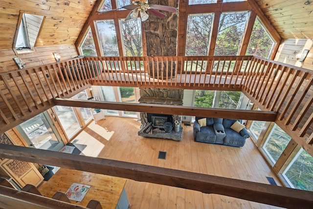 658 High St, West Gardiner, ME 04345 - unfurnished living room with lofted ceiling, hardwood / wood-style flooring, healthy amount of natural light, a ceiling fan, and wood walls