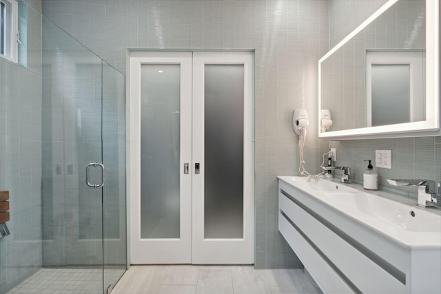 123 Cumberland Ave, Portland, ME 04101 - full bathroom with a stall shower, tile walls, and double vanity