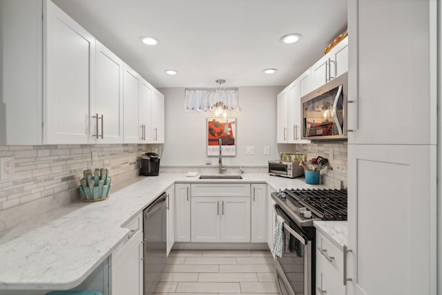 123 Cumberland Ave, Portland, ME 04101 - kitchen with appliances with stainless steel finishes, a sink, tasteful backsplash, white cabinets, and recessed lighting