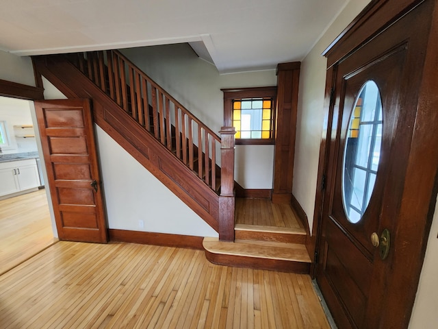 76 Somerset St, Millinocket, ME 04462 - foyer entrance featuring light wood finished floors, stairway, and baseboards