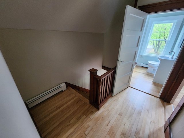 76 Somerset St, Millinocket, ME 04462 - hall featuring baseboard heating, light wood-style flooring, and an upstairs landing
