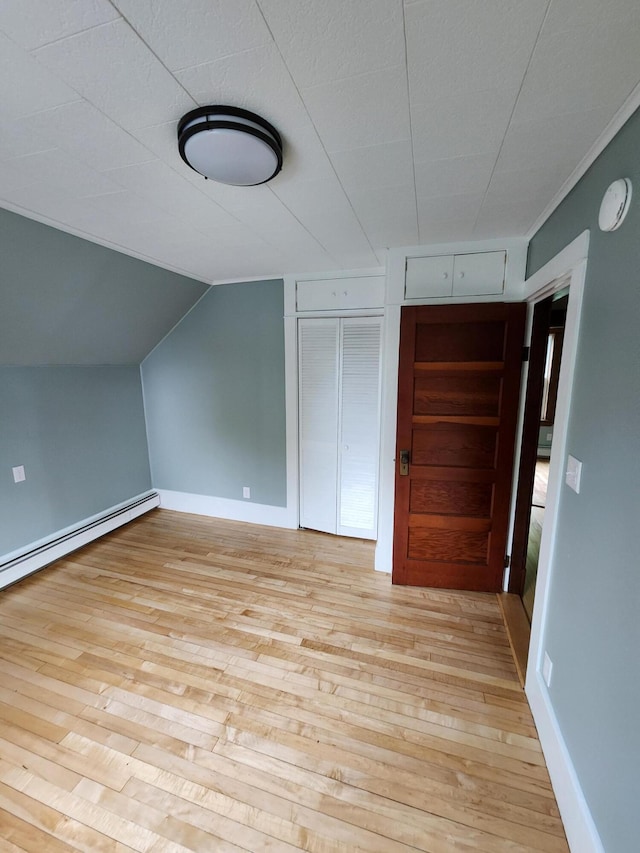 76 Somerset St, Millinocket, ME 04462 - additional living space with light wood finished floors, vaulted ceiling, baseboards, and a baseboard heating unit