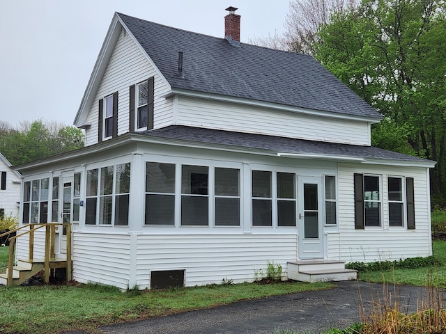 76 Somerset St, Millinocket, ME 04462 - view of home's exterior featuring roof with shingles, entry steps, a chimney, and a sunroom