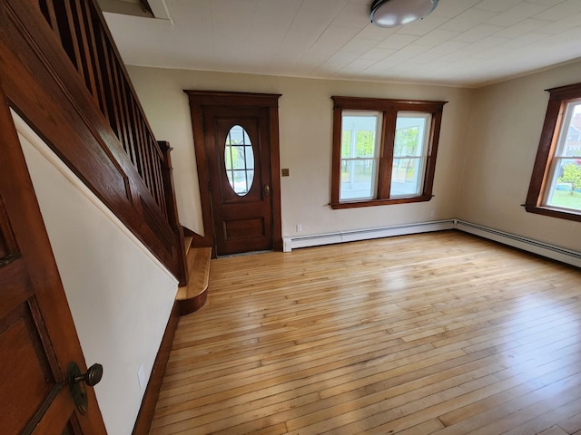 76 Somerset St, Millinocket, ME 04462 - foyer featuring light wood finished floors, a baseboard heating unit, and stairway