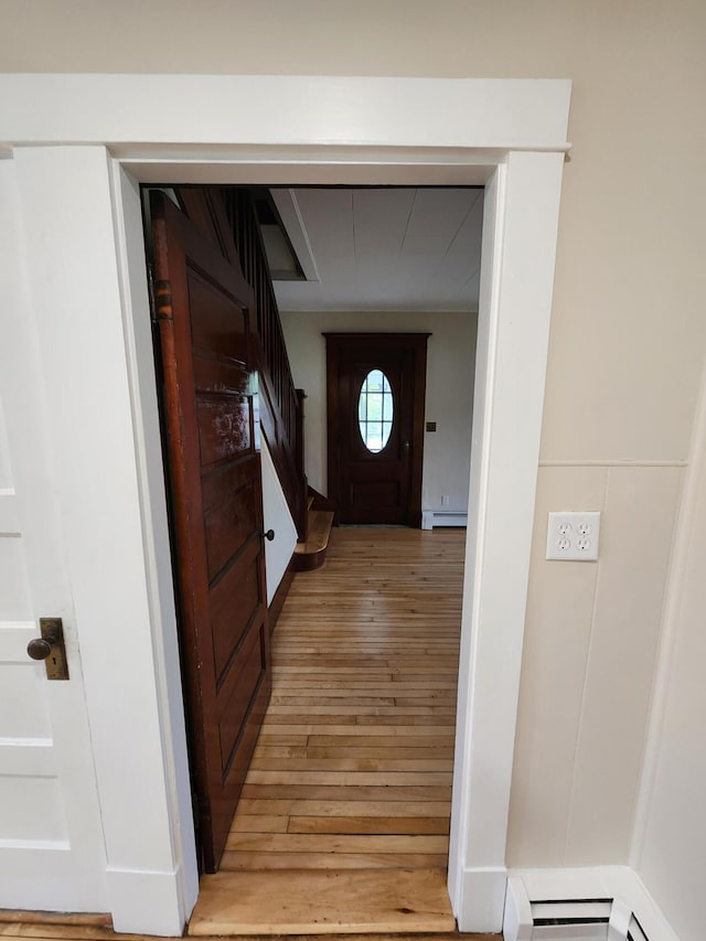 76 Somerset St, Millinocket, ME 04462 - doorway with a baseboard heating unit, light wood finished floors, and stairs