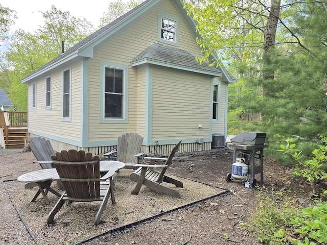 1 Old County Rd Unit 155, Wells, ME 04090 - rear view of property featuring central AC unit, a fire pit, roof with shingles, and a wooden deck