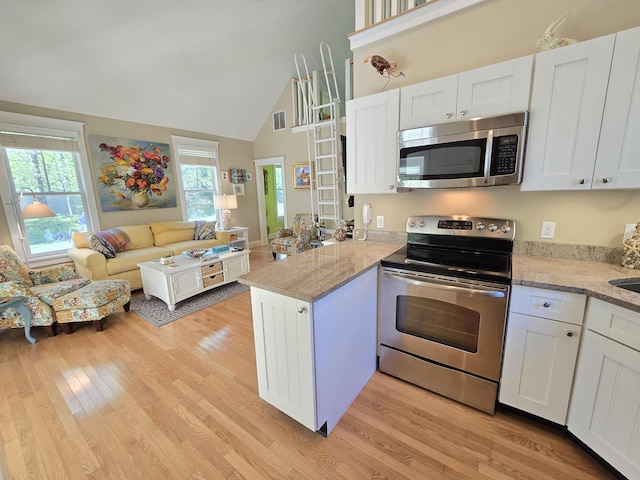 1 Old County Rd Unit 155, Wells, ME 04090 - kitchen featuring stainless steel appliances, open floor plan, a peninsula, light wood finished floors, and high vaulted ceiling