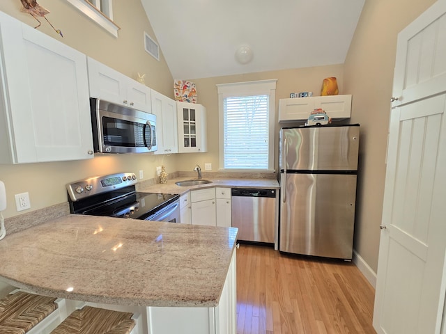 1 Old County Rd Unit 155, Wells, ME 04090 - kitchen with appliances with stainless steel finishes, light stone countertops, glass insert cabinets, white cabinetry, and vaulted ceiling