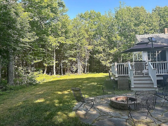 9 Deerfield Dr, Brunswick, ME 04011 - view of green lawn with a fire pit, a patio area, a deck, and a view of trees