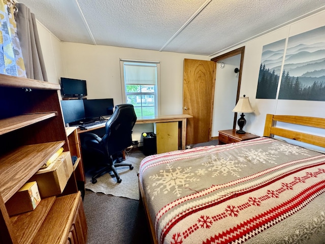 bedroom featuring a textured ceiling, a desk, and carpet flooring