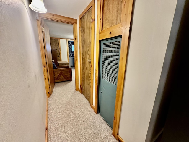 corridor featuring a heating unit and light colored carpet