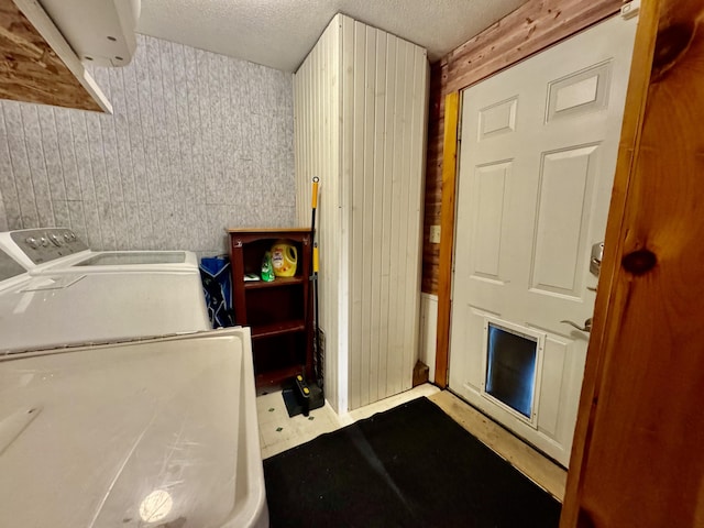 laundry area with washer and dryer and a textured ceiling