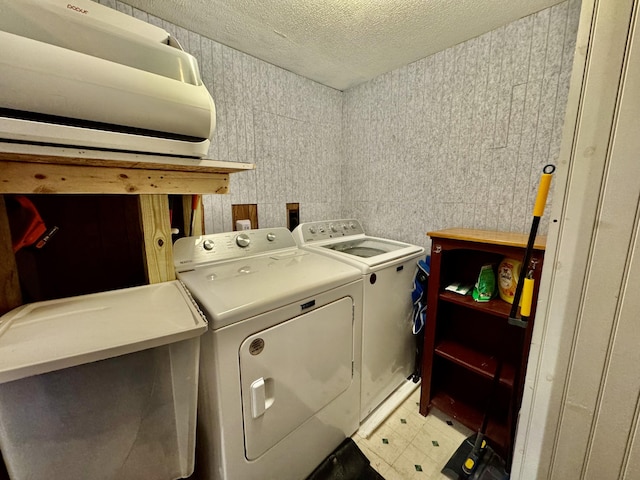 laundry area featuring washer and clothes dryer, a textured ceiling, and light flooring