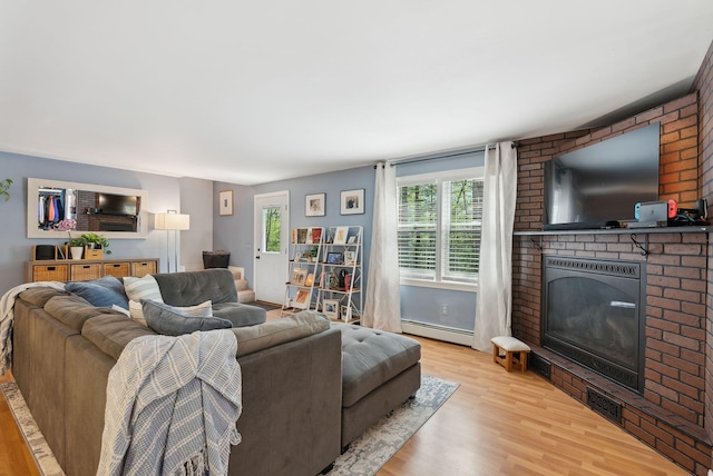 65 Lone Indian Trl, Augusta, ME 04330 - living area featuring a baseboard heating unit, a fireplace, and wood finished floors