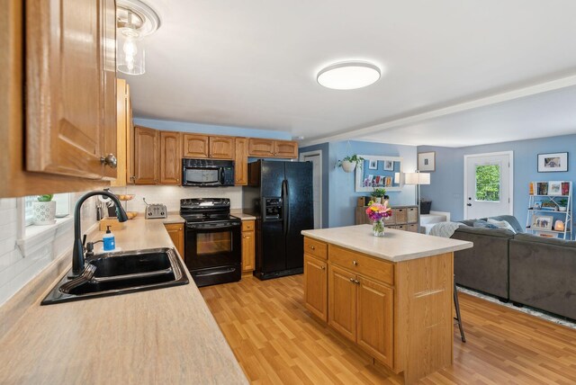 65 Lone Indian Trl, Augusta, ME 04330 - kitchen with black appliances, a sink, open floor plan, and light wood-style floors