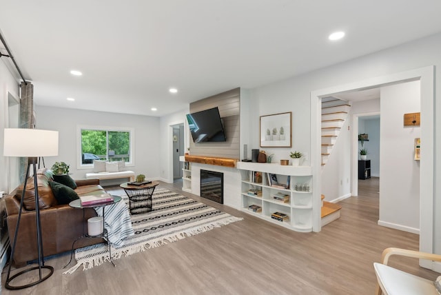 510 Minot Ave, Auburn, ME 04210 - living area featuring wood finished floors, stairway, baseboards, recessed lighting, and a glass covered fireplace