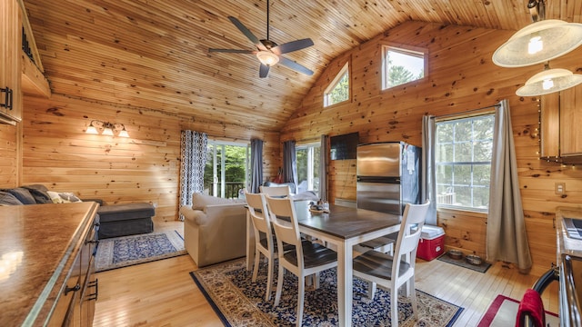 183 Pine Point Rd, Oxford, ME 04270 - dining room with wood walls, ceiling fan, high vaulted ceiling, wooden ceiling, and light wood finished floors