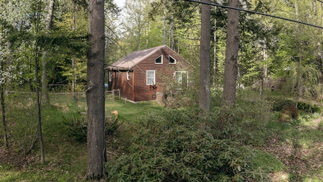 183 Pine Point Rd, Oxford, ME 04270 - view of property exterior featuring log veneer siding, a wooded view, and metal roof