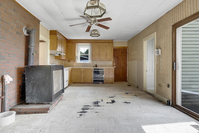 640 Lower St, Turner, ME 04282 - kitchen featuring stove, light countertops, ceiling fan, a wood stove, and a sink