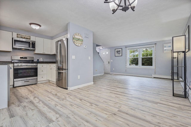 5 Jamestown Ct Unit 5, South Portland, ME 04106 - kitchen featuring appliances with stainless steel finishes, dark countertops, light wood-style flooring, and baseboards