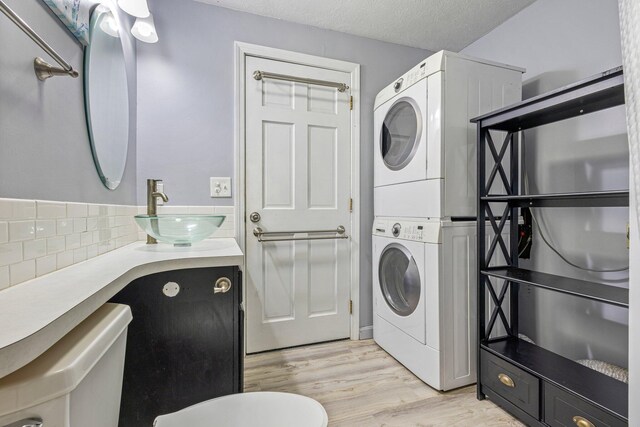 5 Jamestown Ct Unit 5, South Portland, ME 04106 - bathroom with estacked washer and dryer, wood finished floors, toilet, tasteful backsplash, and vanity
