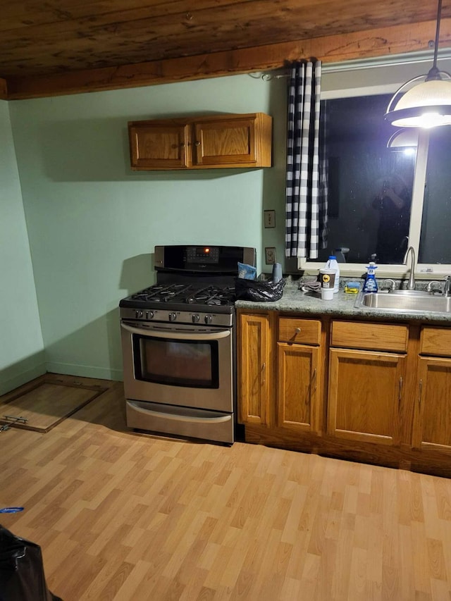 458 Carding Machine Rd, Bowdoinham, ME 04008 - kitchen featuring stainless steel gas range, a sink, light wood-style floors, brown cabinets, and dark countertops