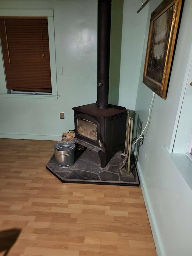 458 Carding Machine Rd, Bowdoinham, ME 04008 - detailed view of baseboards, a wood stove, and wood finished floors