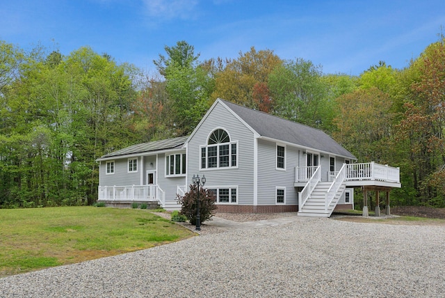 1 Whispering Pines Dr, Old Orchard Beach, ME 04064 - view of front of house with a wooden deck, a front lawn, and stairs