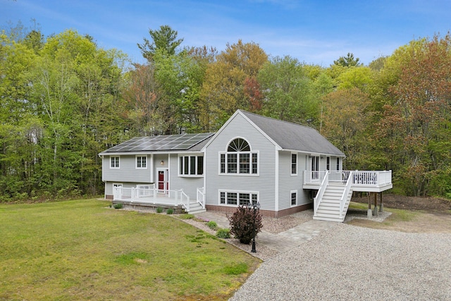 1 Whispering Pines Dr, Old Orchard Beach, ME 04064 - raised ranch featuring a front yard, a wooden deck, roof with shingles, and a forest view
