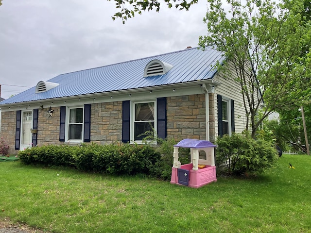 25 Biron Ave, Lewiston, ME 04240 - view of side of property featuring stone siding, a lawn, and metal roof