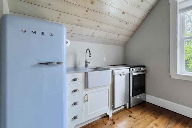 16 Cross St, Camden, ME 04843 - kitchen featuring freestanding refrigerator, dishwasher, lofted ceiling, light wood-style floors, and white cabinets