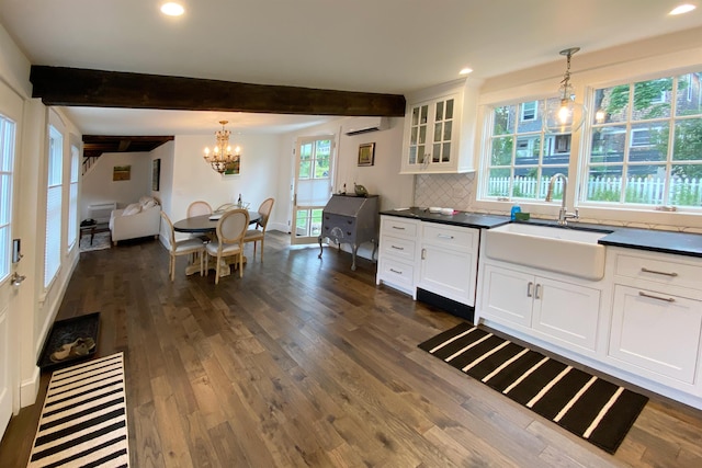 16 Cross St, Camden, ME 04843 - kitchen featuring a sink, a wall mounted AC, dark countertops, a chandelier, and white cabinets