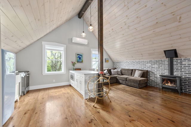 16 Cross St, Camden, ME 04843 - living area with a wall mounted AC, light wood finished floors, a wood stove, wooden ceiling, and baseboards