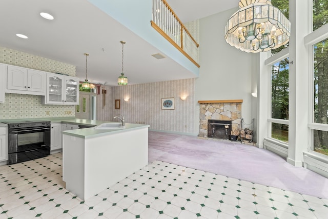 73 Hodsdon Ln, Jefferson, ME 04348 - kitchen with black electric range, a fireplace, white cabinetry, glass insert cabinets, and a towering ceiling