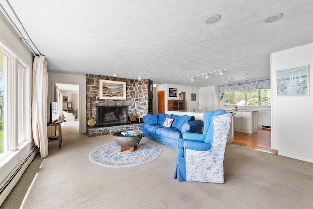 21 Ledge Rd, Cumberland, ME 04110 - living room featuring a baseboard radiator, light colored carpet, and a stone fireplace