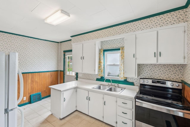 520 Lincoln St, Lewiston, ME 04240 - kitchen featuring electric range, freestanding refrigerator, a sink, wainscoting, and wallpapered walls