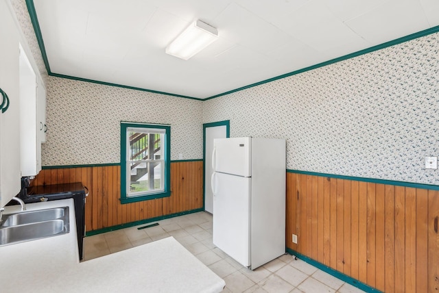 520 Lincoln St, Lewiston, ME 04240 - kitchen featuring freestanding refrigerator, a wainscoted wall, a sink, wood walls, and wallpapered walls