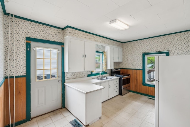 520 Lincoln St, Lewiston, ME 04240 - kitchen featuring stainless steel electric stove, freestanding refrigerator, wallpapered walls, a sink, and a wainscoted wall