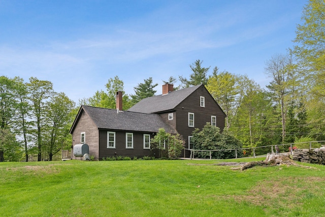 19 Bearce Rd, Winthrop, ME 04364 - view of front facade with oil tank, a front lawn, a chimney, and a shingled roof